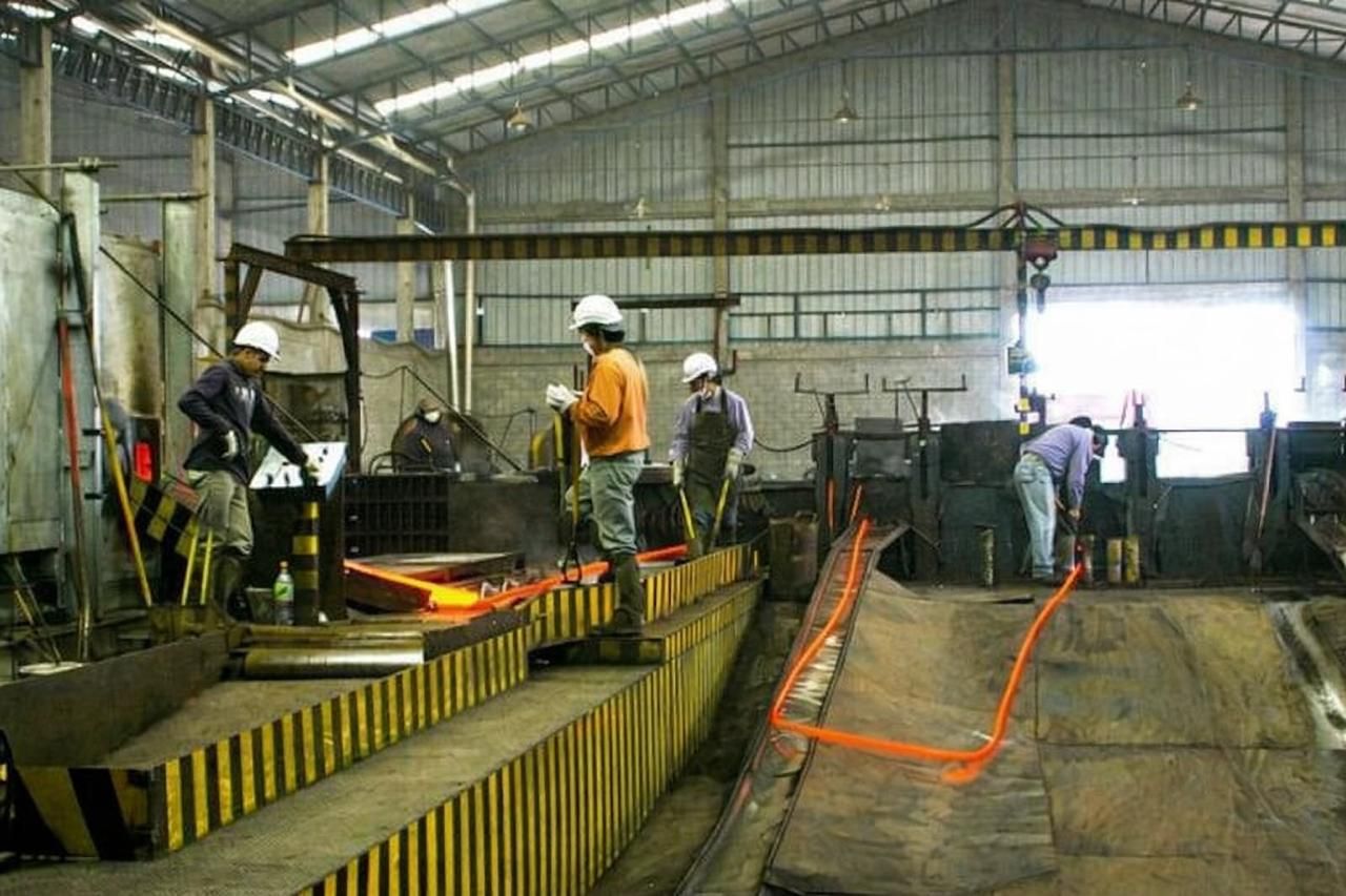 Operarios con EPP trabajando en planta industrial